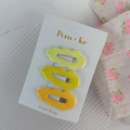 Set di tre fermagli per capelli ondulati giallo sfumato per bambini su carta bianca - Serie Gialla