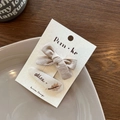 Set of two beige fabric bow hair clips with dark brown 'athee' embroidery and feather detail - Cocoa And Maple Leaf