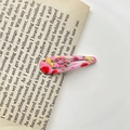 Pink BB hair clip with colorful strawberry and lemon patterns on an open book - 30# Banana