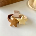 Braune und beige elastische Haargummis mit glänzenden Sternanhängern auf Displaykarte - Pentagramm