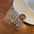 Set of five matte gray teardrop BB hair clips in handmade packaging on wooden desk - Light Gray