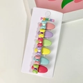 Set van 6 kleurrijke haarspelden met strikjes in roze, paars en blauw op een displaykaart - Ovale Strik Haarclip