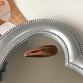 Single brown matte water-drop BB clip for kids displayed on a silver mirror tray - Coffee