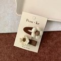 Two-piece brown fabric flower hair clips set with cream floral accents on display card - White Flower + Flower