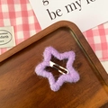 Molletta a stella in lana viola su un vassoio di legno con sfondo estetico dolce - Viola