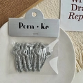 Set mit fünf silbernen Glitzer-Stern-Haarspangen für Mädchen auf einem Porzellanteller - Meteorform Außen-Glitzer