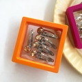 Five silver metal hair clips with amber rhinestones in an orange display box - Orange Series