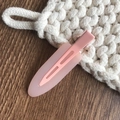 Pinza para el pelo de gota rosa mate para mujer con muelle sobre fondo de madera - Rosa