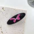 Fermaglio ovale nero con stampa a fiocco rosa su elegante base in pietra naturale - Fiocco Rosa