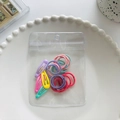 Colorful hair accessory set with metal snap clips and elastic bands in a white dish - Small Scrunchies And Hair Clips Combination