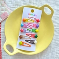 Lot de 10 pinces à cheveux Mickey colorées pour filles, présentées sur une assiette jaune - Carré Coloré