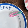 Pink and white checkered hair clip with a mint green base shown on a decorative plate - Pink and White Plaid