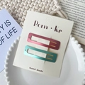 Set of two minimalist rectangular metal hair clips in deep pink and teal blue on display card - Pink and Green