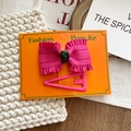 Set of stylish fuchsia bow hair clip and pink triangle matte hairpin on orange display card - Magenta Bow And Pink Triangle Hair Clips Set