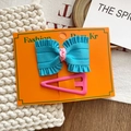 Set de pinza de lazo azul plisado y horquilla rosa sobre una tarjeta de exhibición naranja - Set de Lazo Azul Cielo Y Pinza Triangular Rosa