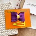Purple pleated bow hair clip with yellow triangle base on display card - Dark Purple Bow And Neon Yellow Triangle Hair Clips Set