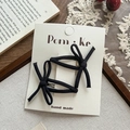 Pair of handmade black bow hair clips on display card with vintage props - Black Series
