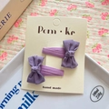 Set of two handmade purple bow hair clips with textured fabric on a minimalist paper card - Purple
