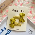 Pair of ginger yellow fabric bow hair clips on a handmade brand display card - Matcha Green