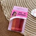 Glittery red and orange kids hair clips set in a pink storage box on a woven mat - Red Series