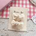 Pair of cream white mesh bow hair clips for girls on minimalist cardboard packaging - Knotted Bow Style