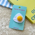 Handmade felt hair clip with cute poached egg design on a blue presentation card - Fried Egg Hair Clip