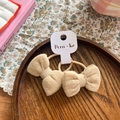 Paar beige Stoff-Haarschleifen mit elastischen Bändern auf rustikalem Holzdisplay - Schleifen-Haargummi (NK1133) / Aprikose