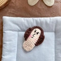 Pinza para el pelo tejida a mano con adorable personaje de dibujos animados y fondo azul - Expresión de enfado