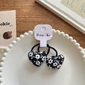 Pair of heart-shaped hair ties featuring black fabric with white floral print design - Black Heart White Floral Hair Tie