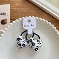 Pair of heart-shaped floral fabric hair ties with black and white print on a lace plate - White Heart Black Floral Hair Tie