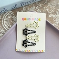 Set aus vier sternförmigen Polka-Dot BB-Haarspangen in Gelb und Schwarz auf Karte - Glücksstern Punktmuster