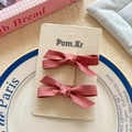 Set of two red suede bow hair clips for kids on a branded Pom.Kr display card - Deep Pink