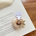 Détail de breloques tricotées en cœur et fleur sur un chouchou marron pour enfant - Élastique Cœur Ours Beige