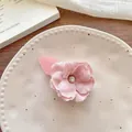Détail d'une pince à cheveux fleur rose en tissu avec un centre en strass étincelant - Épingle à Cheveux Florale Rose