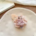 Detailed macro view of pink chiffon flower hair clip with pearls on ceramic plate - Beige Flower Hair Clip