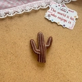 Jolie broche en tissu marron en forme de cactus avec broderie blanche sur fond liège - Style Cactus