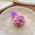 Close-up of elegant floral hair clip with pink and purple chiffon petals on ceramic plate - Light Purple Flower Hair Clip