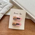 Detail of two pink flocked bear burger hair clips on a warm aesthetic wooden background - Bear Burger / Pink