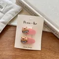 Detail of two pink flocked bear burger hair clips on a warm aesthetic wooden background - Bear Burger / Pink