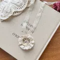 Detailaufnahme des Vintage-Spitzenhalsbands mit filigranem floralen Stickerei-Anhänger - Blumen Spitze Stirnband