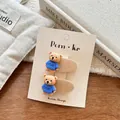 Detail of two cute cartoon bear hair clips on a Korean design display card - Blue Shirt Bear / Off White