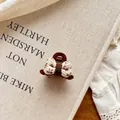 Gros plan d'une mini pince à cheveux nœud papillon en tissu marron et blanc sur dentelle - Pince Crabe Nœud Marron