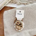 Detail der karierten Spitzenblumen-Haarklammer mit Vintage-Katzenanhänger - Haargummi / Gelbes Spitze Haargummi