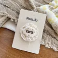 Gros plan d'accessoire cheveux en dentelle beige avec broderie Earth sur carte - Pince à Cheveux Dentelle Lettre Beige