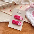 Detail of pink plaid bow hair clips with buttons on a textured paper display card - Plaid Button Style