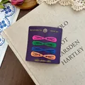 Set of 8 colorful matte metal BB hair clips in vibrant colors on a vintage book backdrop - Colorful