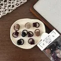 Detail view of retro elastic hair ties in earthy tones featuring diverse button shapes - Dark Color Button Hair Tie