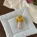 Dettaglio di una spilla a fungo in tessuto fatta a mano con ricami su un supporto trapuntato - Fungo Giallo (NK1352)