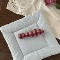 Detail of cute red and white checkered fish doll on a light blue quilted soft pad - Red Grid Fish (NK1352)