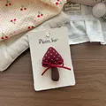 Dettaglio dell'accessorio per capelli in tessuto a forma di fungo su cartoncino espositivo - Fermaglio a Fungo a Pois